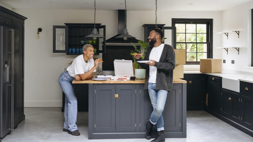 Two people eating and chatting in modern kitchen