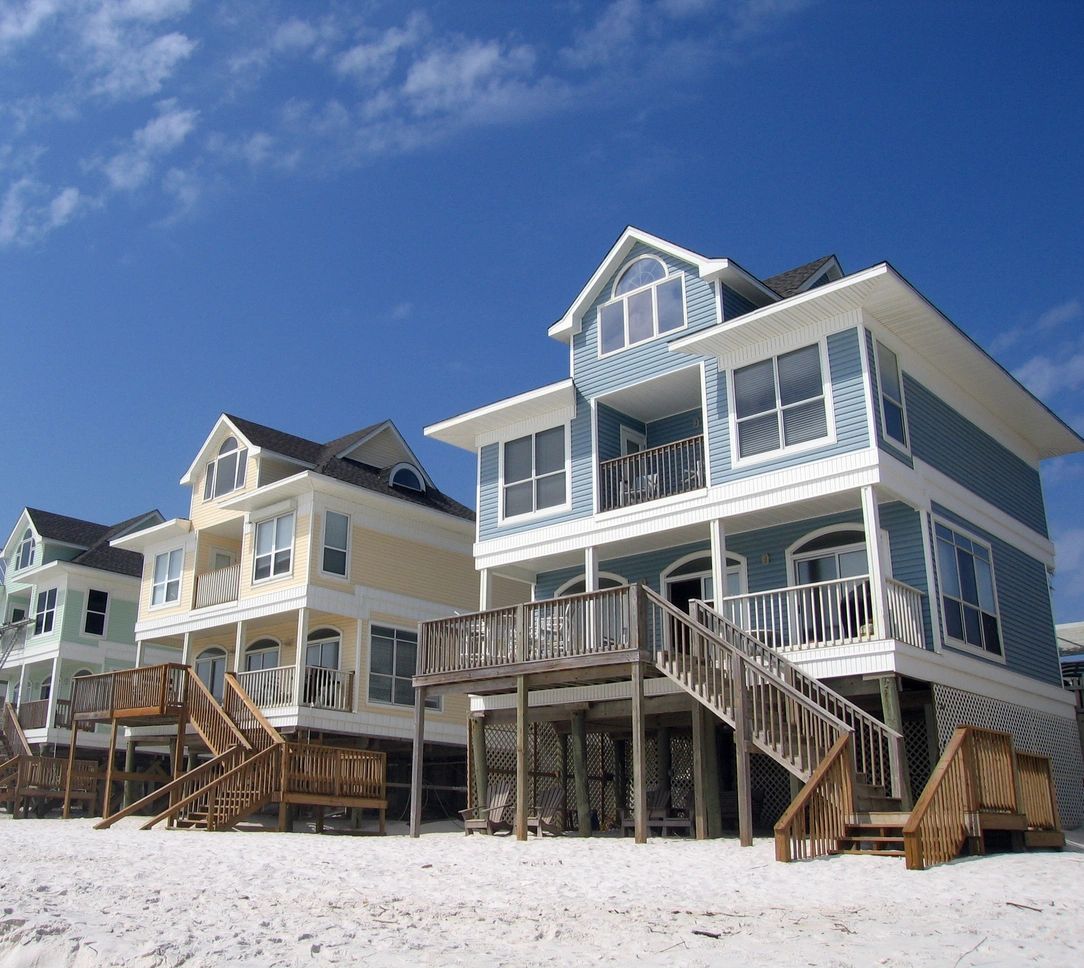 Colorful stilted beach houses on sandy shore
