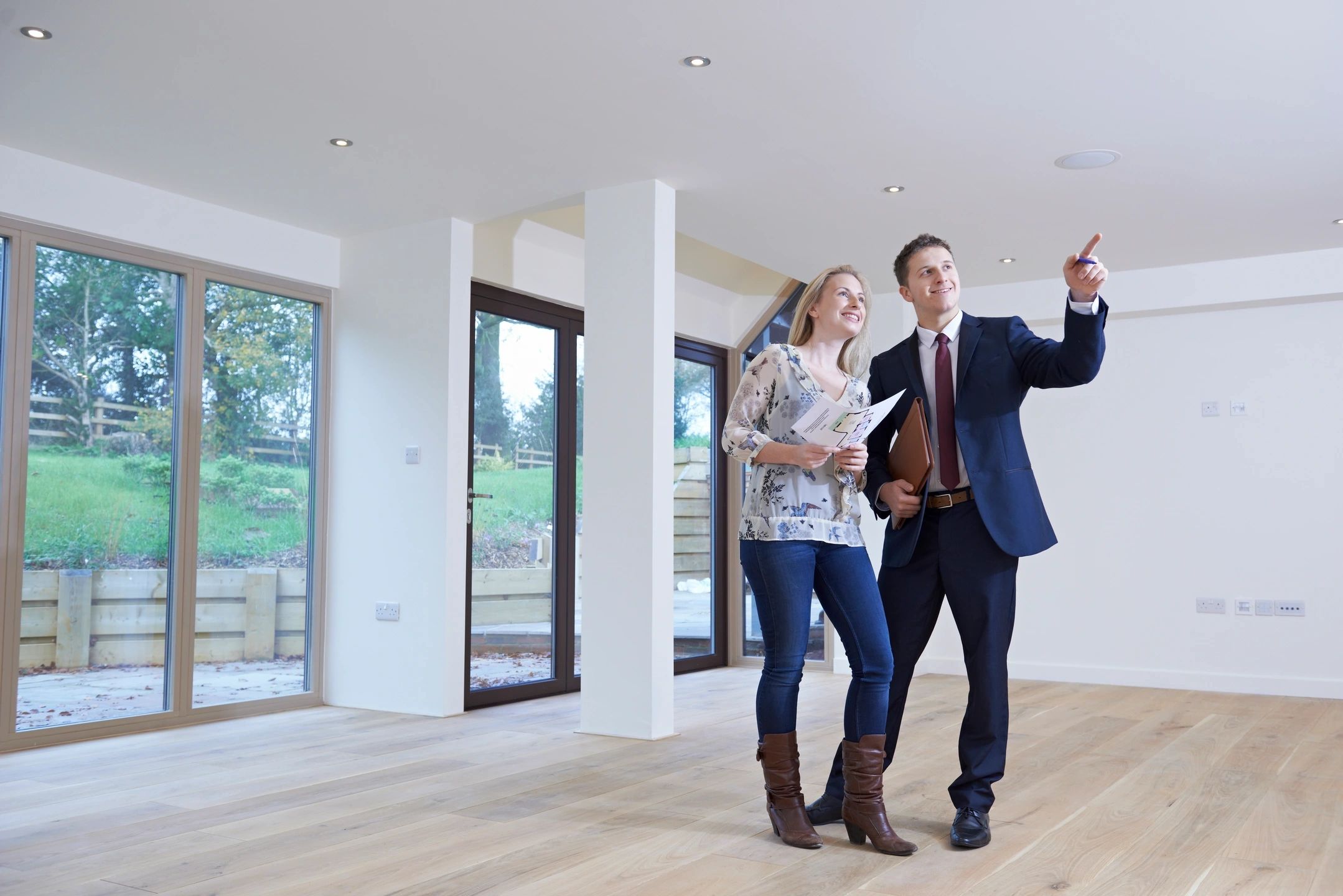 Real estate agent showing woman empty living room