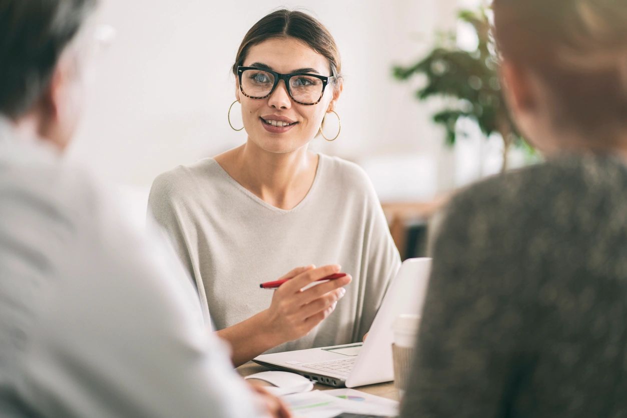 Woman consultant advising clients at desk