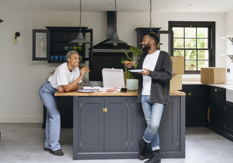Two people eating and chatting in modern kitchen